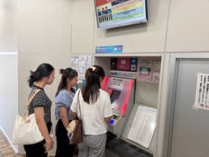 JR伊部駅で運賃や切符の購入方法、ICカードの利用方法について説明を受ける実習生