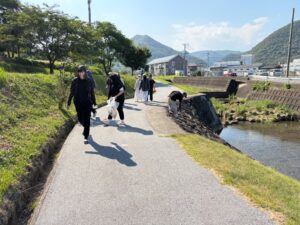 川沿いを歩きながらゴミを拾う実習生たち